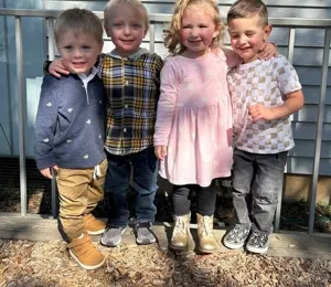 Four friends standing together on the playground
